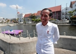 Indonesian President Joko Widodo smiles as he talks to The Associated Press during his visit at the newly revitalized 18th century Kali Besar Canal at the Old Town in Jakarta, Indonesia, July 26, 2019.