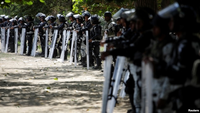 Fuerzas de la Guardia Nacional de México custodian la ribera del río en Ciudad Hidalgo el 21 de enero de 2020 para impedir el paso de la caravana de migrantes centroamericanos.