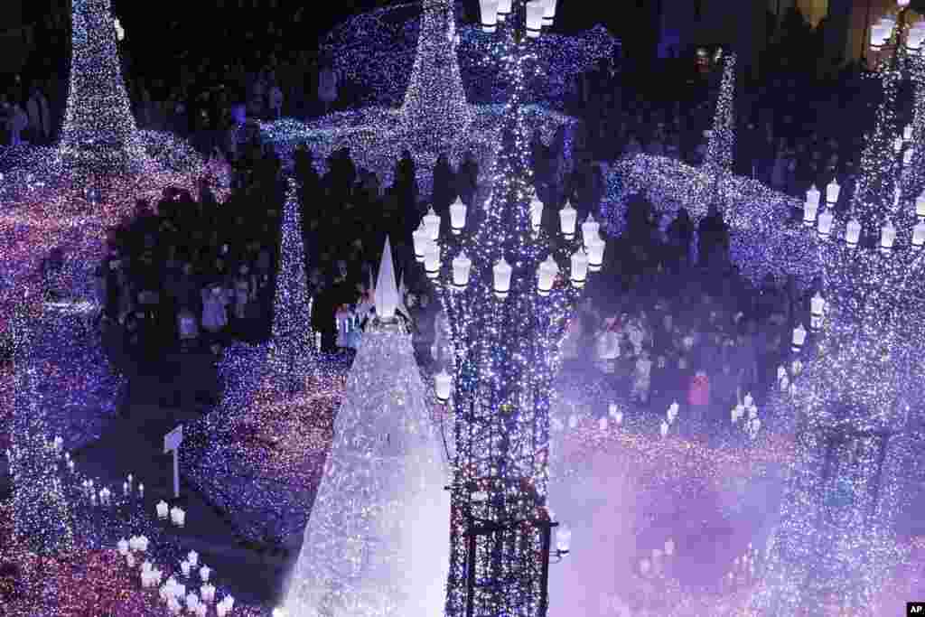 بازدیدکنندگان در حال تماشای چراغانی های نصب شده به مناسبت تعطیلات کریستمس در ژاپن