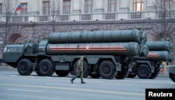 FILE - A Russian serviceman walks past a S-400 missile defense system, displayed as part of a parade, in central Moscow, Russia, April 29, 2019.