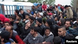 Migrants wait in front of a registration camp for migrants in Opatovac, Croatia, Sept. 22, 2015. 
