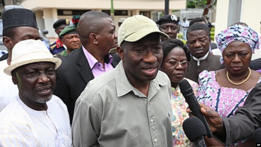 Nigeria President Goodluck Jonathan, center, speak to journalists, August 27, 2011 after visiting the explosion site at the United Nation's office in Abuja, Nigeria