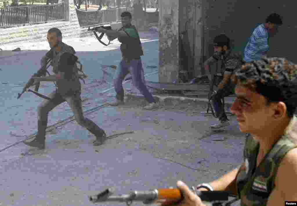 Free Syrian Army fighters fire their rifles during clashes with Syrian Army soldiers in the Salah al- Din neighbourhood of central Aleppo August 5, 2012.