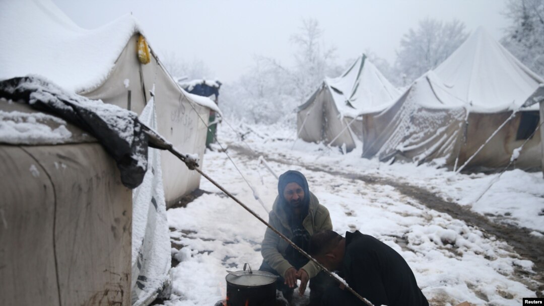 Migrants prepare a breakfast in a snow covered makeshift forest camp near Croatian border in Bihac, Bosnia and Herzegovina December 3, 2019. REUTERS/Dado Ruvic