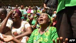 FILE - Women mourn the death of Tanzanian President John Magufuli during the national funeral at Uhuru Stadium in Dar es Salaam, March 20, 2021. 