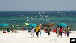 FILE- Beach goers enjoy Pensacola Beach in Pensacola, Florida, July 11, 2010.