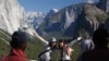 Visitors at Tunnel View, like Kaori Nishimura and Eriko Kuboi from Japan, pose in front of Half Dome, center facing, during the reopening of Yosemite National Park, Calif., Oct. 17, 2013. 