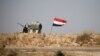 A military vehicle of the Iraqi security forces is seen next to an Iraqi flag in Fallujah, Iraq, June 13, 2016. An operation to liberate the city from Islamic State militants is now in its third week.