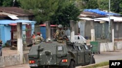 Members of the Armed Forces of Guinea drive through the central neighborhood of Kaloum in Conakry, Sept. 5, 2021 after sustainable gunfire was heard.