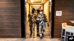 Junta soldiers walk through a hotel during a meeting with high level representatives from the Economic Community of West African States (ECOWAS), in Conakry, Guinea, Sept. 17, 2021.