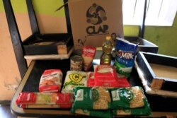 ARCHIVO - El contenido de una caja CLAP, un folleto del gobierno venezolano con suministros básicos de alimentos, se muestra en la casa de Viviana Colmenares en el barrio pobre de Petare en Caracas, Venezuela, el 23 de febrero de 2018.