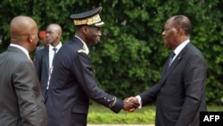 Le président ivoirien Alassane Ouattar, à droite, serre la main avec le chef d'état-major des Forces armées de Côte d'Ivoire (FACI), le général Sékou Touré, à gauche, lors d'une cérémonie de voeux du Nouvel An au palais présidentiel, Abidjan, 4 janvier 2018