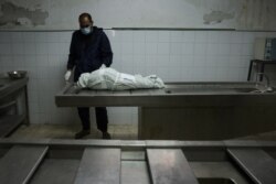 Seorang pria Palestina berdiri di dekat tubuh Menna Shreir, 3, di kamar mayat di Kota Gaza, setelah dia meninggal karena luka-lukanya setelah serangan udara Israel di rumahnya, yang juga menewaskan orang tuanya. (Foto: AFP)
