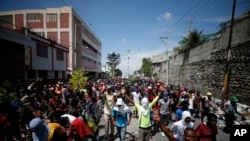 Haitians respond to a nationwide push to block streets and paralyze the country's economy as they press for President Jovenel Moise to give up power, in Port-au-Prince, Haiti, Sept. 30, 2019.
