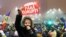 FILE - A woman holds up a sign that reads "government without corruption" during a demonstration of thousands of Romanians against their government in Bucharest, Romania, Feb. 6, 2017. 