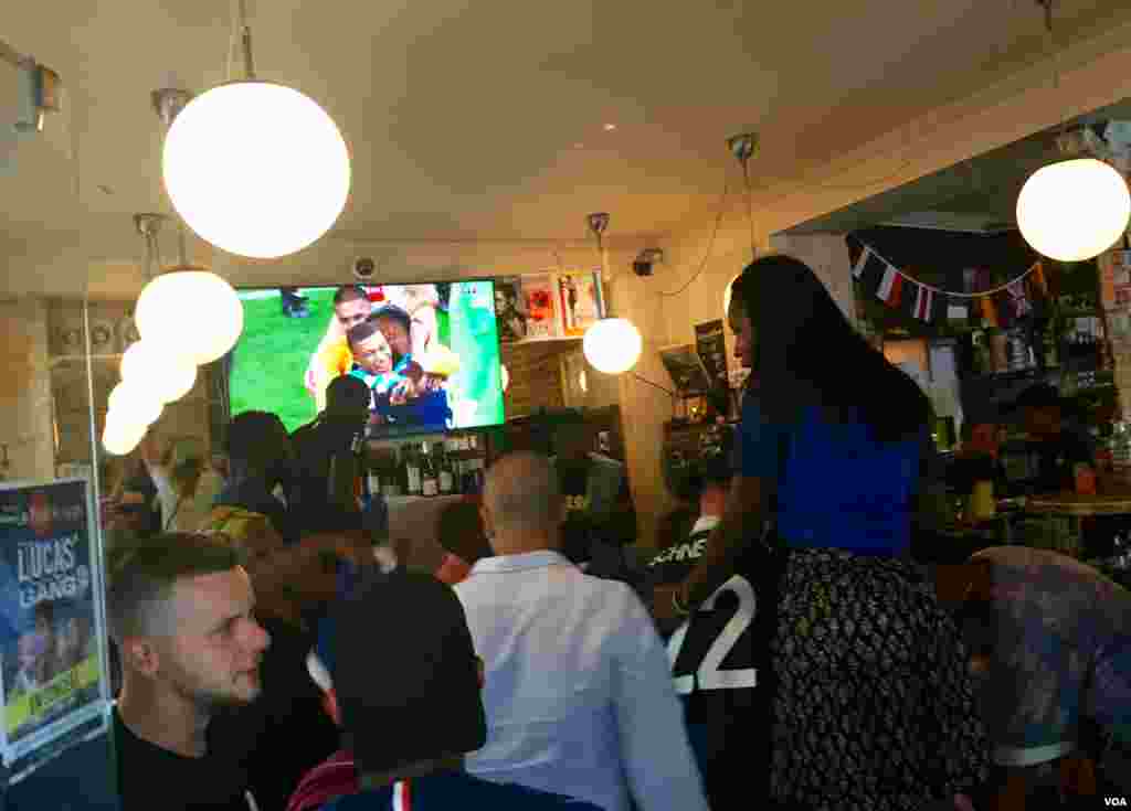 People celebrate the French team's World Cup victory at bar, in Paris, France, July 15, 2018. (L. Bryant/VOA)