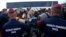 Hungarian police officers stop a group of migrants before a bus that would take the migrants in Roszke, southern Hungary, Sept. 8, 2015. 