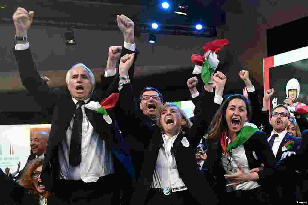 Members of Milano-Cortina deligation celebrate after the cities won the bid to host the 2026 Winter Olympic Games, at the SwissTech Convention Centre in Lausanne, Switzerland.