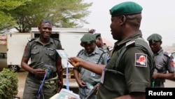 A police officer hands out security tags during the distribution of election materials at the INEC office in Yola, Adamawa state, ahead of the country's presidential election, in Yola, Nigeria, Feb. 15, 2019.