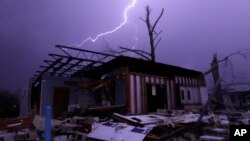 Lightning illuminates a house after a tornado touched down in Jefferson County, Ala., damaging several houses in Birmingham, Dec. 25, 2015.