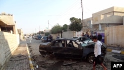 An Iraqi looks at damages on the site of a car bomb attack in the northern city of Kirkuk, Nov. 14, 2013. 