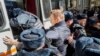 In this photo provided by Evgeny Feldman, Alexei Navalny is detained by police in downtown Moscow, March 26, 2017. 