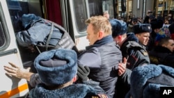 In this photo provided by Evgeny Feldman, Alexei Navalny is detained by police in downtown Moscow, March 26, 2017. 