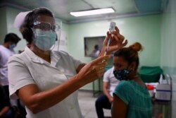 Seorang perawat bersiap menyuntik vaksinasi seorang tenaga kesehatan dengan dosis kedua kandidat vaksin COVID-19 Kuba, Abdala, di Cienfuegos, Kuba, 30 Mei 2021. (Foto: Yamil LAGE / AFP)