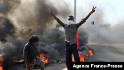 Sudanese protesters burn tires to block a road in 60th Street in the capital Khartoum, to denounce overnight detentions by the army of members of Sudan's government, on Oct. 25, 2021.