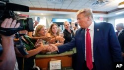 ARHIVA - Bivši predsednik Tramp se pozdravlja sa pristalicama u restoranu Versaj u Majamiju, 13. juna 2023. (Foto: AP/Alex Brandon)