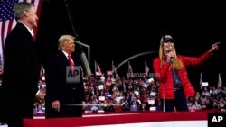 FILE - In this Dec. 5, 2020, file photo Sen. Kelly Loeffler, R-Ga., speaks as President Donald Trump and Sen. David Perdue, R-Ga., listen at a campaign rally at Valdosta Regional Airport, Dec. 5, 2020, in Valdosta, Georgia. 