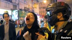A protester is detained by a riot police officer during an anti-government rally outside Prince Edward MTR station in Hong Kong, China, Nov. 30, 2019.