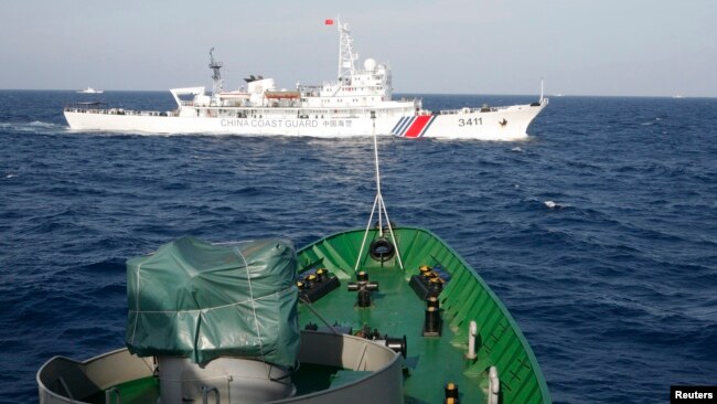 Tàu hải cảnh Trung Quốc (trên) và tàu Cảnh sát biển Việt Nam trong vụ đụng độ vào tháng 5 năm 2014 khi Trung Quốc kéo giàn khoan Hải Dương 981 vào khu vực gần quần đảo Hoàng Sa, nơi cả hai nước đều tuyên bố chủ quyền.