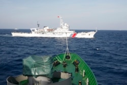 FILE - A ship (top) of Chinese Coast Guard is seen near a ship of Vietnam Marine Guard in the South China Sea, about 210 km (130 miles) off shore of Vietnam, May 14, 2014.