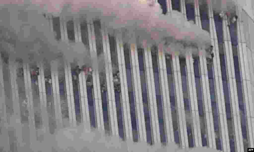 People hang out of broken windows of the North Tower of the World Trade Center after a terrorist attack in New York on the morning of Sept. 11, 2001. (AP Photo/Amy Sancetta)