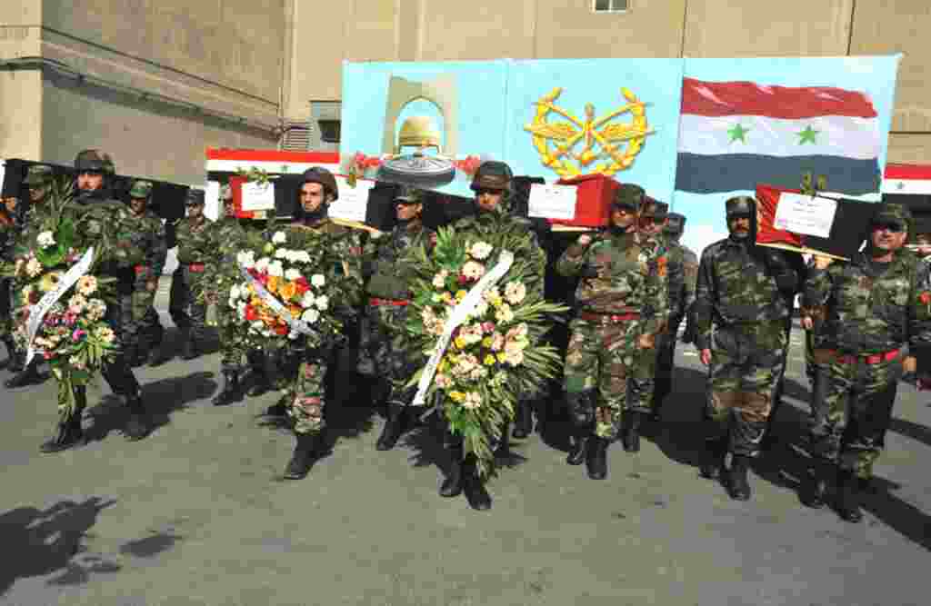 Syrian soldiers carry coffins of their colleagues during a funeral ceremony in Damascus, February 9. (Reuters)