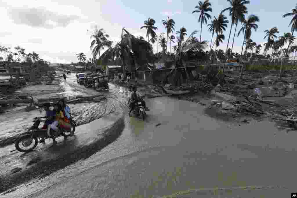 Residents make their way through a flooded area of New Bataan township, Compostela Valley, Philippines, December 5, 2012, a day after Typhoon Bopha made landfall.