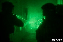 FILE - Green Berets assigned to 10th Special Forces Group (Airborne) aim down a hallway during a training exercise with Lithuanian Special Forces in Eastern Europe, Nov. 13, 2017.