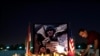 FILE - A man lays flowers next to a photo of James Foley, the freelance journalist killed by the Islamic State group, during a memorial service in Irbil, Iraq, Aug. 24, 2014.