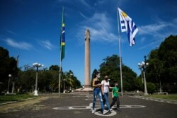 ARCHIVO - La gente camina en la Plaza Internacional, en medio de la pandemia de la enfermedad del coronavirus (COVID-19), en la frontera de la ciudad brasileña de Santana do Livramento y la ciudad uruguaya de Rivera, Uruguay, 19 de marzo de 2021.