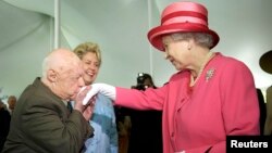 FILE: Actor Mickey Rooney (L) kisses the hand of Britain's Queen Elizabeth II during a garden party celebrating her state visit to the U.S. at the British Embassy in Washington, May 7, 2007. 