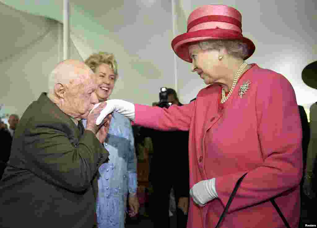 Mickey Rooney kisses the hand of Britain&#39;s Queen Elizabeth II during a garden party celebrating her state visit to the U.S. at the British Embassy in Washington, D.C., May 7, 2007.