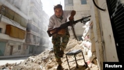 A Free Syrian Army fighter takes cover during clashes with Syrian Army in central Aleppo in this August 7, 2012 photo.