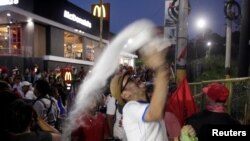 A demonstrator throws a plastic bag with white powder during a protest against the government of President Juan Orlando Hernandez, whose brother was found guilty of U.S. drug trafficking charges, in Tegucigalpa, Oct. 18, 2019.