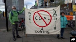 Protesters hold a banner against mining coking coal in the West Cumbria area of northern England, as they stand near the Scottish Event Campus, the venue for the COP26 U.N. Climate Summit in Glasgow on Nov. 2, 2021.