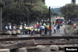 Orang-orang berkumpul di dekat truk yang terbakar di pintu masuk jembatan tempat sebuah truk tangki bensin meledak di Boksburg dekat Johannesburg. (Foto: Reuters)