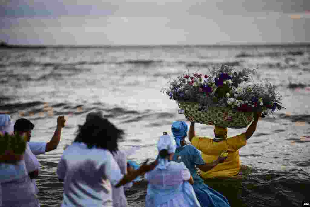 A priest of the Afro-American Umbandista cult launches a basket with offerings into the sea to Iemanja, the African goddess of the sea, at Ramirez beach in Montevideo, Feb. 2, 2019.