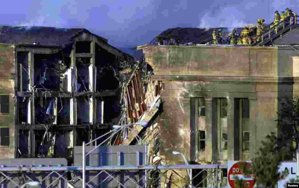 Firefighers work on the roof of the Pentagon after a hijacked aircraft crashed into it.