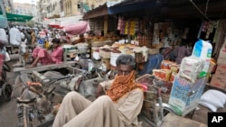 FILE - Buruh menunggu pekerjaan di pasar, di Karachi, Pakistan, Kamis, 13 Juli 2023. (AP/Fareed Khan)