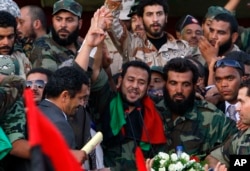 FILE - Abdel Hakim Belhaj (center), Libyan National Transitional Council military commander of Tripoli at the time, waves prior to his speech at Saha Kish Square in Benghazi, Libya, Oct. 23, 2011, as Libya's transitional government declared the liberation of Libya after months of bloodshed that culminated in the death of longtime leader Moammar Gadhafi.